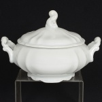 PORCELANA, uma (1) terrina com tampa, tonalidade branca, modelada em gomos e volutas, sem marca de manufatura aparente, medindo 22 cm diâmetro mais as alças, sinais de uso, vide foto.