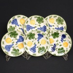 FAIANÇA, seis (6) pratos de sobremesa, ornamentação  policromada pintada a mão, representando frutas, manufatura LUIZ SALVADOR (destacado mestre da arte de pintura em faiança na olaria de Alcobaça em Portugal, veio para o Brasil e fundou no ano de 1950 uma fábrica em Itaipava, região serrana do Rio de Janeiro, ainda em atividade), possui o craquelê característico do envelhecimento de toda a faiança, medindo 20 cm diâmetro, sinais de uso, vide foto.
