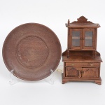 DIVERSOS, dois (2) itens confeccionados em madeira: 1 louceiro miniatura para casa de bonecas, falta um dos pés na parte de traz e um adorno na parte superior, medindo 15,5 cm altura; 1 presentoir torneado, medindo 14 cm diâmetro, ambos com sinais de uso, vide foto.