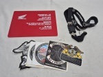 Lote diverso com adesivos para moto, placa em acrílico da Honda e chaveiro. Medindo a placa 20cm x 15cm.