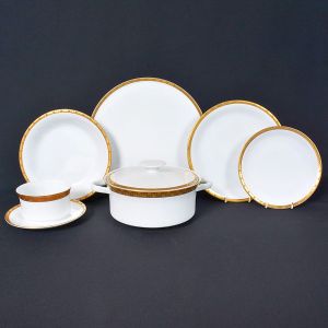 <b>Serviço para jantar</b>  em porcelana alemã Rosenthal, branca com borda dourada. Constando de 24 pratos rasos, 12 pratos fundos, 10 pratos para sobremesa, 11 xícaras p/ chá, 11 xícaras p/ café, 11 taças p/ "consommé", bule p/ chá, bule p/ café, leiteira, açucareiro, 1 sopeira redonda, 1 molheira, 1 saladeira redonda, 1 travessa redonda, 2 travessas ovais (25 cm), 2 travessas ovais de (34 cm), 2 travessas ovais de (38 cm). Marcas da manufatura no verso. Total de 93 peças.