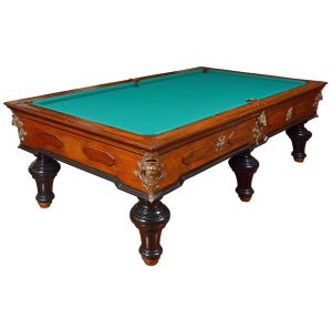 Antiga <b>mesa de bilhar</b>, inglesa, com estrutura em madeira nobre de acabamento parcialmente ebanizado. Ricamente adornada por cantoneiras e ornamentos em metal dourado fundido, com aplique frontal em forma de cabeça de leão em alto-relevo. Tampo com revestimento em feltro verde, moldura chanfrada e cantos decorados. Assenta-se sobre quatro pés torneados de formato bolacha. Med. 82 x 294 x 164 cm
