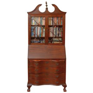 "<b>Bookcase</b>" em mogno, de estilo colonial inglês. Parte superior com duas portas envidraçadas em caixilharia formando desenho geométrico, encimada por frontão recortado com pináculo central. Parte inferior com tampo "abattant" formando escrivaninha com escaninhos e pequenas gavetas internas. Base com quatro gavetas de frente sinuosa apoiadas sobre pés "cabriolet". Med. 197 x 80 x 40 cm
