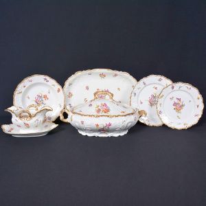 <b>Serviço para jantar </b>em porcelana francesa de Limoges, decorada com flores e bordas douradas. Constando de 36 pratos rasos, 11 pratos fundos, 30 pratos p/ sobremesa, 1 legumeira c/ tampa, 3 travessas redondas, 2 travessas ovais, 1 molheira c/ "presentoir", 2 covilhetes ovais, 1 fruteira de pé baixo, e 1 terrina p/ molho s/ tampa. Marcas da manufatura no verso. Total de 88 peças.