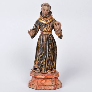 Rara e belíssima imagem de <b>São Francisco Penitente</b>, em madeira policromada e entalhada, apresentando finas feições e vestes de plissados longilíneos realçados a ouro. À mão esquerda a caveira simbolizando a meditação sobre a brevidade da vida, o desapego dos bens materiais e a importância da espiritualidade. Base marmorizada e chanfrada. Séc. XVIII. Alt. 27 cm