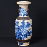 <b>Vaso </b>chinês em cerâmica, com pintura azul e branco e aplicações em bronze. Corpo ornamentado com decoração em azul cobalto representando pavões entre peônias. Faixa com padrão geométrico em relevo no ombro e base, com apliques de máscaras felinas em bronze nas alças. Esmalte com craquelê visível típico de idade. Apresenta ideograma chinês na base. Alt. 61 cm
