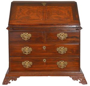 <b>Papeleira </b>brasileira em jacarandá. Tampo reclinável, revelando interior com gavetinhas e escaninhos. Caixa reta apresentando dois gavetões superpostos encimados por par de gavetas alinhadas. Puxadores flexíveis em bronze dourado. Quatro pés em volutas e contra volutas, apresentando sobre a quina concheado estilizado. Med. aberta 126 x 111 x 70 cm 