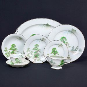 <b>Serviço de jantar </b>em porcelana Noritake, decorado com paisagem oriental estilizada em tons de verde e cinza, com filetes prateados nas bordas. Marca "Noritake  Nippon Toki Kaisha" no verso. Constando de 12 pratos rasos, 12 pratos fundos, 12 pratos de sobremesa, 12 pratos p/ pão, 2 travessas ovais, 1 fruteira e 5 xícaras c/ pires. Total de 56 peças.
