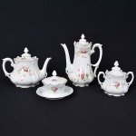 <b>Conjunto de chá</b>, em porcelana alemã, R.S. Germany. Modelo de linhas sinuosas e relevo rococó, decorado com ramalhetes de rosas em tons de rosa e verde, com acentos em dourado nas bordas e alças. Composto por bule, cafeteira, açucareiro com tampa e leiteira. Total de 4 peças. Apresenta pequenos bicados e fio de cabelo. Alt. da cafeteira 26 cm
