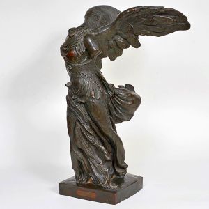 Grande <b>escultura </b>em bronze patinado, representando a célebre deusa Niké, Vitória Alada de Samotrácia. Trabalho de fundição, possivelmente francês, séc. XX. Réplica inspirada no original helenístico do séc. II a.C., atualmente no Museu do Louvre, Paris. Apresenta base retangular também em bronze, com placa identificadora gravada. Alt. 70 cm