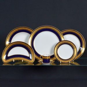 <b>Serviço de jantar </b>em porcelana francesa Limoges, apresentando fundo branco com barrado em azul cobalto e friso a ouro decorado com arabescos. Marca da manufatura no verso. Constando de 23 pratos rasos, 12 pratos fundos, 12 pratos de sobremesa, 12 pratos p/ pão, 11 covilhetes meia lua e 8 xícaras p/ café com pires. Total de 78 peças.