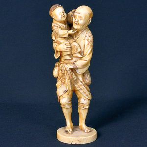 <b>Okimono japonês </b>em marfim, representando figura masculina portando criança ao colo. Escultura cuidadosamente entalhada, destacando-se pelos trajes decorados com padrões minuciosos e expressão jovial das personagens. Belíssimo exemplo do entalhe seccional característico do período Meiji (1868-1912). Apresenta selo na base. Alt. 19 cm