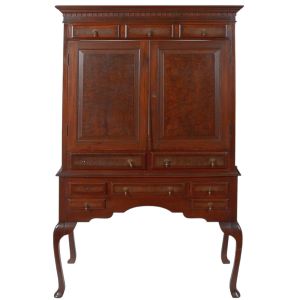 <b>Móvel contador </b>em madeira nobre, com parte superior com duas portas e cinco gavetas menores, e parte inferior com sete gavetas dispostas em diferentes formatos. Apresenta pés em voluta no estilo Queen Anne, com recortes sinuosos e acabamento levemente abaulado. Possui ainda bandeja deslizante lateral embutida. Med. 185 x 108 x 39 cm