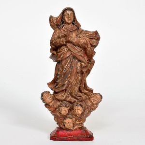 Imagem de <B>Nossa Senhora da Conceição </B>em madeira entalhada e policromada, apoiada sobre base com nuvens e cabeças de anjos aladas. A Virgem apresenta-se de pé, com as mãos postas ao centro do peito. Veste túnica e manto de pregas abundantes, com vestígios de policromia em tons ocres e douração original. Alt. 17 cm