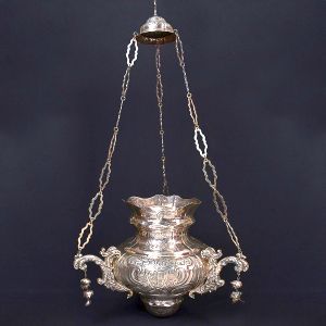Belíssimo e raro <b>lampadário </b>barroco, de invulgar formato, em prata, tendo ao centro brasão de armas ladeado por angras e bojo lavrado com elementos vegetais. Triplos braços de sustentação com relevo em volutas e elementos arredondados pendentes. Alças em elos ovalados, movimentados e vazados. Séc. XIX Alt. 120 cm