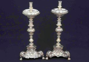 Raro <b>par de tocheiros </b>em prata espanhola do séc. XVIII. Parte superior expandida sobre haste movimentada. Base trípode terminada em pés de garras sobre esferas. Belíssimos trabalhos lavrados em rocalhas e volutas em composições barrocas. Contraste da cidade de Córdoba de 1732 e marca do prateiro DIEGO. Alt. 55 cm