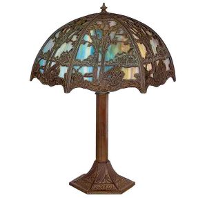 "<b>Abatjour</b>" em metal patinado, de inspiração Art Nouveau, com base sextavada ricamente moldada em relevo vegetalista. Haste facetada sustentando cúpula semicircular em vitral marmorizado multicolor, protegida por delicada armação metálica rendilhada representando paisagem com árvores e construções. Alt. 58 cm