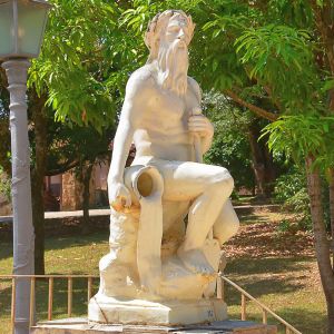 <b>Escultura </b>em cerâmica esmaltada representando figura mitológica masculina, sentado, com ânfora derramando água e apoiado em cajado, aludindo ao rio Tejo. Base marcada "Fábrica de Santo Antônio  Porto". Perdas significativas no verniz e na modelagem, com craquelê evidente em toda a superfície.