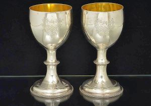 <b>Par de cálices</b>  em prata inglesa do séc. XVIII, do período George III. Bojos lisos com brasão armorial lavrado. Haste e base perolados. Interior em "vermeil". Contraste da cidade de Londres de 1774 e marca parcialmente ilegível de prateiro provavelmente WALTER BRIND. Peso 500 gramas. Alt. 17 cm