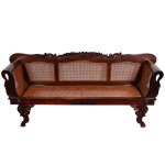 <b>Canapé </b>em madeira nobre de tom escurecido, com encosto e assento em palhinha trançada. Encosto levemente arqueado, dividido em três secções, encimado por entalhes vegetalistas. Braços curvos com recortes orgânicos e pernas em volutas entalhadas. Brasil, séc. XIX / XX. Compr. 224 cm