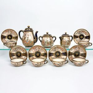 <b>Serviço para chá </b>em porcelana japonesa, decorado em policromia com reservas, com figuras orientais em um jardim sobre fundo azul escuro e detalhes em dourado. Constando de bule p/ chá, leiteira, açucareiro e 6 xícaras c/ pires. Total de 9 peças. Marcas no verso. Alt. do bule 16 cm