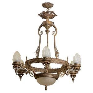 <b>Lustre </b>em bronze, com seis braços ornados por volutas e frisos florais. Cúpulas em vidro opalino em formato de chama e globo central em vidro leitoso com decoração em relevo. Corpo suspenso por estrutura de hastes curvas com arremate superior ricamente cinzelado. Alt. 90 cm