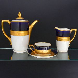 <b>Conjunto de chá </b>em porcelana branca tcheca, decorado com faixa superior em azul cobalto, ornada por friso dourado com motivos geométricos e figuras. Composto por bule, leiteira e 8 xícaras com pires. Marcação ao verso da manufatura Union / Karlovy Vary, Tchecoslováquia.