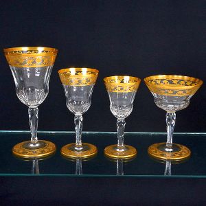 <b>Serviço de copos </b>em cristal francês Saint Louis, moldado com gomos e ornamentado por frisos com arabescos em ouro. Constando de 5 copos p/ água, 8 copos p/ vinho tinto, 8 copos p/ vinho branco e 7  taças p/ "champagne". Total de 28 peças.