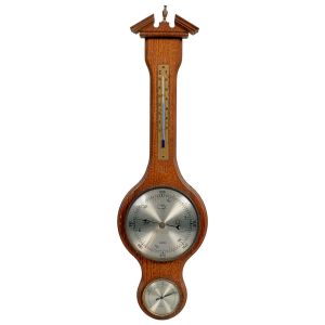<b>Barômetro de parede</b>, em madeira entalhada, com termômetro e higrômetro integrados, INCOTERM  Alemanha. Mostradores circulares em metal escovado com indicação de pressão atmosférica e condições climáticas simbólicas (sol, lua e nuvens). Alt. 55 cm