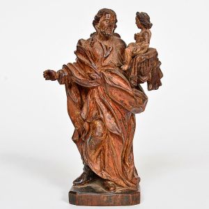 Imagem em madeira entalhada e policromada, representando <B>São José de Botas com o Menino Jesus </B>ao colo, ao gosto da imaginária luso-brasileira. Vestes de pregueados volumosos com vestígios de douração e policromia originais. Base octogonal. Alt. 16 cm