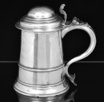 "<b>Tankard</b>" em prata inglesa, do período George III, séc. XVIII. Apresenta bojo liso com frisos, tampa abobadada e alça em "S" terminada em coração. Contraste da cidade de Londres de 1771 e marca do prateiro WALTER BRIND. Peso 690 gramas. Alt. 20 cm