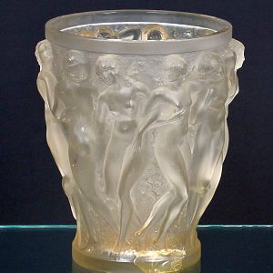 <b>LALIQUE, RENÉE </b>- "Vase aux Nymphes". Vaso em cristal francês fosqueado moldado em alto relevo com figuras femininas. Bordas circulares lisas. Marca gravada sob a base R. Lalique - France. Apresenta restauro na base. Alt. 24,5 cm; Diâm. 21 cm