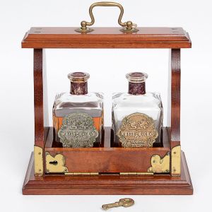 <b>Licoleiro</b>, "cellarette" em madeira com ferragens em metal dourado, contendo duas garrafas quadrangulares em cristal com rótulos metálicos da marca Whyte & Mackay  21 Years Old Scotch. Acompanha chave original para travamento frontal. Alt. 24 cm