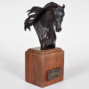 <b>D. MOSS - Escultura </b>em bronze patinado, representando busto de cavalo árabe com crina ao vento, sobre base paralelepipédica em madeira. Na parte frontal, placa metálica com a inscrição "Aza Destiny". Assinada e numerada 24/30 na base. Alt. 27 cm