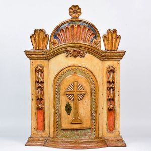 Belo <B>sacrário </B>em madeira entalhada com rica policromia, apresentando arcada em gomos encimados por uma roseta. Almofadas com guirlandas nas laterais. Porta com borda serrilhada com a cruz ao centro. Peça datada do ano de 1803. Med. 90 x 65 cm