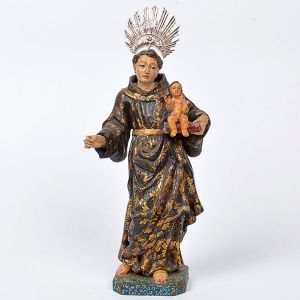 Bela imagem de <B>Santo Antônio com o Menino </B>em madeira entalhada e policromada com fartos realces em volutas a ouro brunido. À mão esquerda, o Menino sobre o evangelho. Resplendor em prata e olhos de suave expressão. Séc. XVIII. Alt. 23 cm