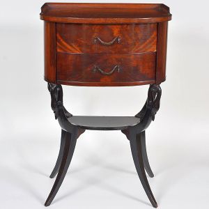 <b>Mesa auxiliar </b>em madeira, com tampo semi abaulado e duas gavetas frontais com puxadores metálicos. Estrutura apoiada sobre pés recurvos unidos por prateleira inferior, com entalhes figurativos nas junções superiores. Med. 71 x 48 x 36 cm