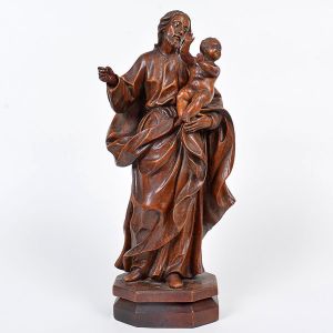 Belíssima imagem de <b>São José de Botas </b>em madeira com vigorosa talha erudita, destacando o movimento das vestes. O Menino apoia-se sobre o braço esquerdo do santo. Olhos em contas e base chanfrada. Início do séc. XIX. Alt. 43 cm