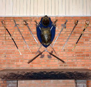 250300503 - Conjunto decorativo composto por armadura 8 espadas e 2 machadinhas. Escudo central em m