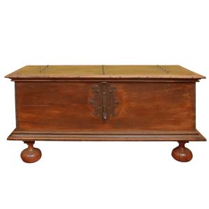 <b>Arca </b>em madeira, de estilo colonial brasileiro, com tampo reto reforçado por ferragens em ferro batido. Frente lisa com fechadura recortada. Base frisada apoiada sobre pés bolacha torneados. Med. 84 x 169 x 70 cm