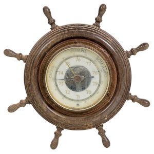<b>Barômetro de parede</b>, em formato de leme náutico, executado em madeira torneada com mostrador circular em metal esmaltado, com inscrições "Chuva / Variável / Bom Tempo". Selo da marca HUGER na parte posterior.