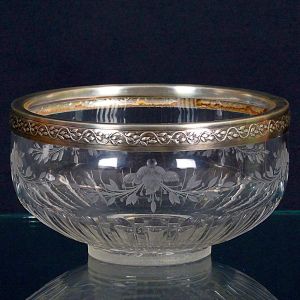 "<b>Bowl</b>" em cristal francês lavrado com guirlandas floridas com borda revestida em prata francesa decorada com goivos. Contraste "Cabeça de Mercúrio", teor 950 ml e marca do prateiro G. B. Séc. XIX. Diâm. 15 cm