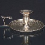 <b>Palmatória </b>circular em prata inglesa georgeana, repuxada e cinzelada com gomos e borda perolada. Descanso de polegar recortado. Contrastes da cidade de Londres de 1805 e marca do prateiro R. C. Compr. 16 cm