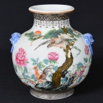 <b>Vaso </b>em porcelana chinesa policromada, decorado com cenas de aves entre peônias e pinheiro. Alças laterais em forma de máscaras zoomórficas esmaltadas em azul. Apresenta ideograma chinês na base. Alt. 14 cm