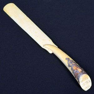<b>Abridor de cartas </b>em marfim, com cabo ricamente adornado com aplicação metálica decorada em volutas e arabescos, gravado "SOCIÉTÉ LAVENIR 1894". Lâmina suavemente curvada, em peça única. Compr. 25 cm