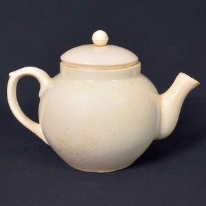 <b>Bule </b>em porcelana esmaltada na cor marfim, formato bojudo com tampa original e pomo esférico. Apresenta craquelê natural do tempo em toda a superfície. No verso, marca da manufatura Lozur. Alt. 15 cm