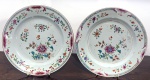 <b>Par de pratos </b>circulares, em porcelana Companhia das Índias decorada em policromia florida nos esmaltes da Família Rosa predominando tonalidades de rosa e turquesa. Um com fio de cabelo. Diâm. 23 cm