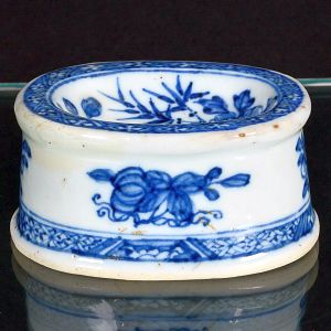 <b>Saleiro </b>de coleção, de forma ovalada, em porcelana Companhia das Índias decorada em azul índigo "underglaze" com frutos e flores. Borda em arabescos. Período Qianlong. Séc. XVIII. Compr. 8 cm