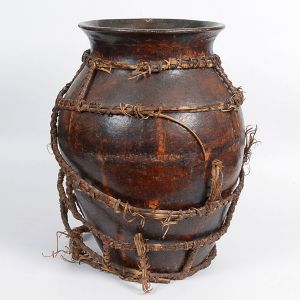 <b>Vaso </b>utilitário em cerâmica esmaltada, revestido por trama artesanal em fibras naturais entrelaçadas. Superfície com pátina escurecida pelo tempo e marcas de uso coerentes à função. Alt. 55 cm