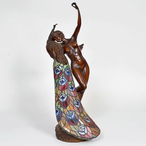 <b>PHILIPPE WOLFERS - Luminária </b>representando figura feminina abraçada a pavão. Corpo em metal patinado e cauda estilizada em vitral policromado, estilo Art Nouveau. Base assinada. Alt. 69 cm